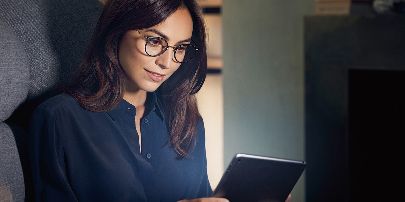 Femme lisant avec des lunettes sur une tablette